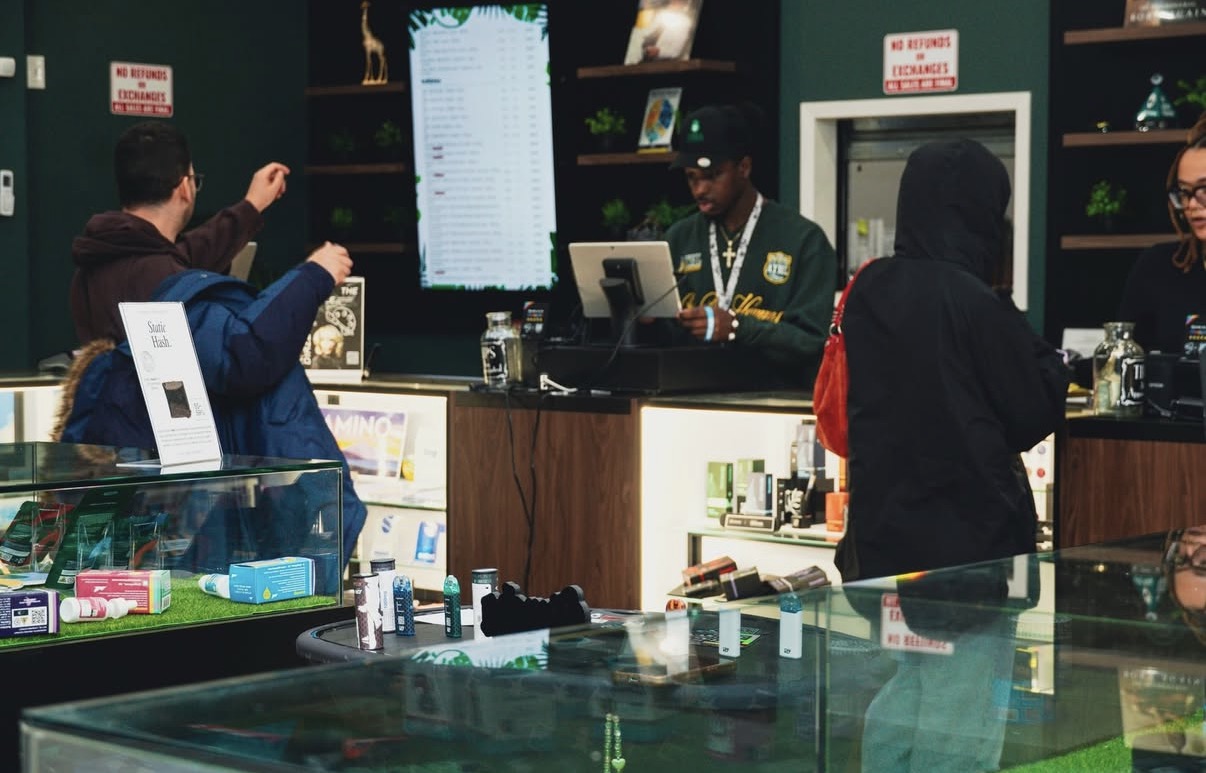Budtenders helping customers at the counter inside Jungle Kingdom Flower, Brooklyn