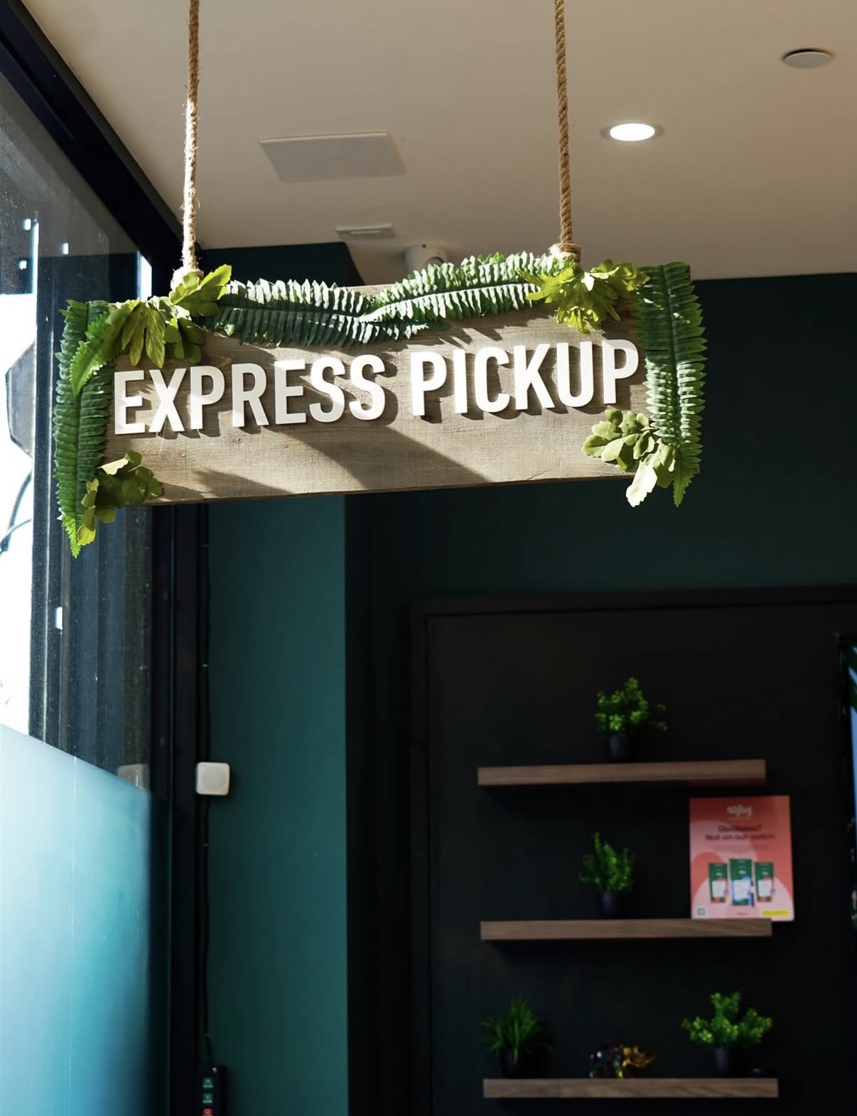Express Pickup sign with tropical plants at Jungle Kingdom Flower dispensary